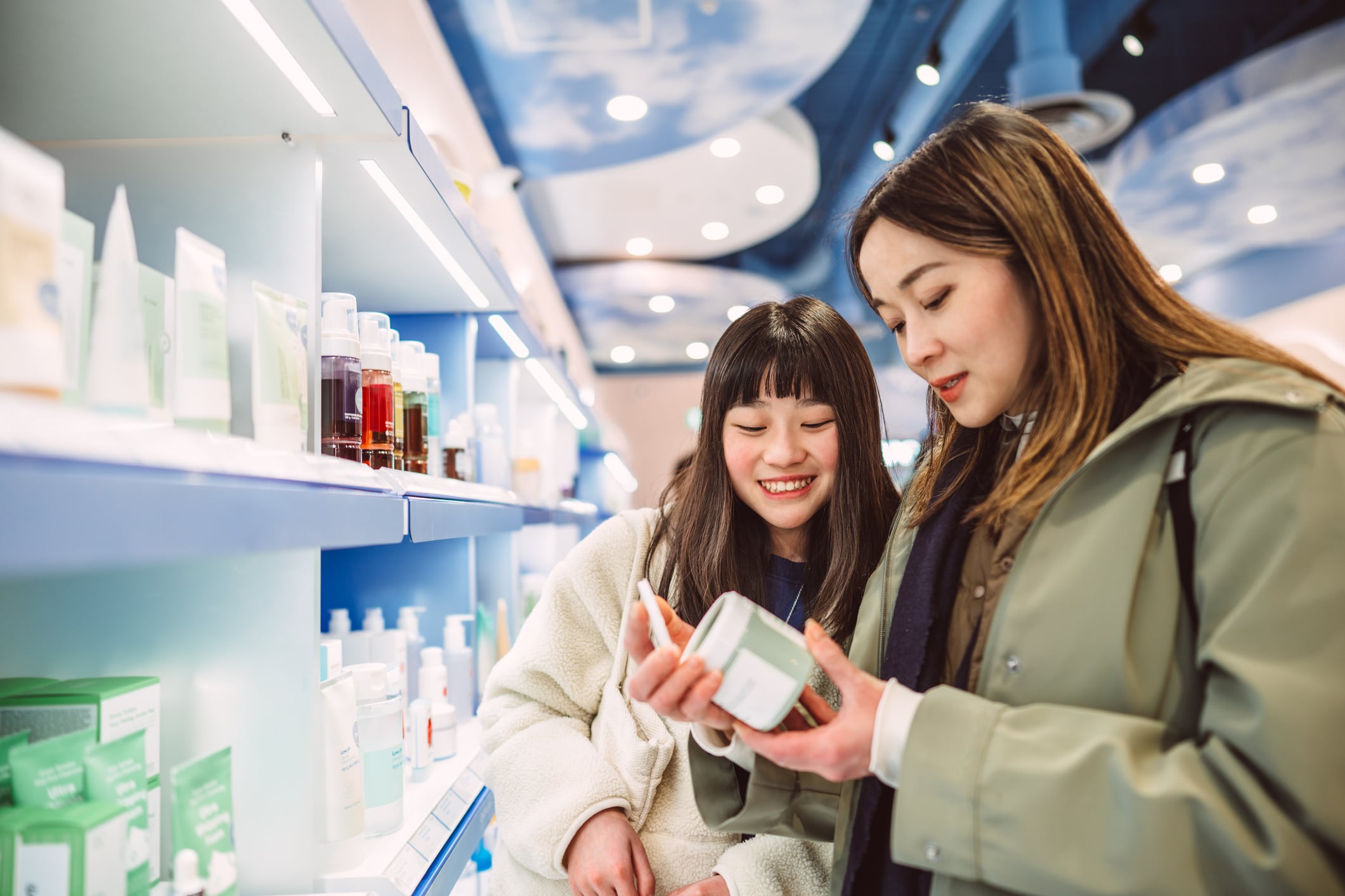 Asian mother and daughter choosing skin care products